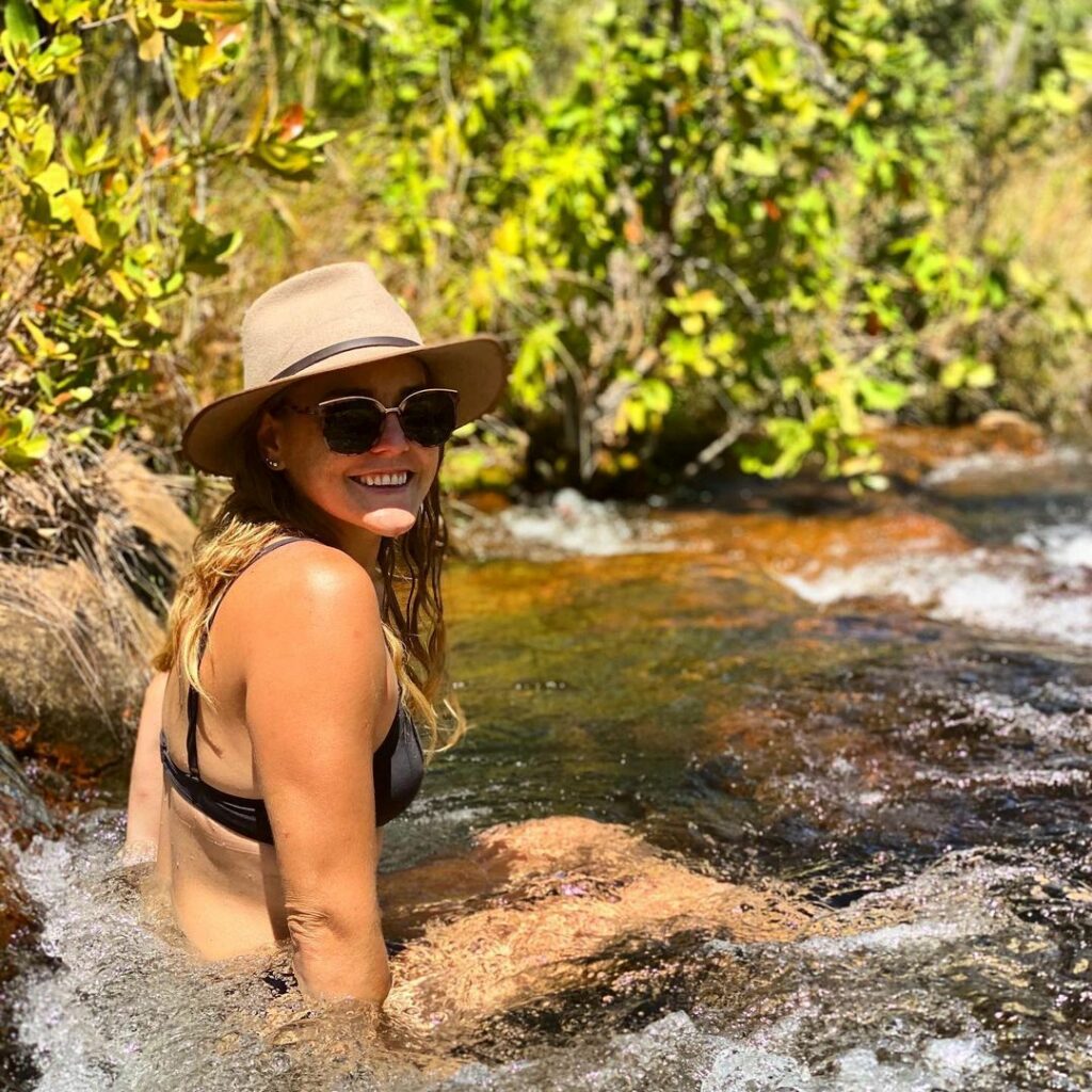 woman with akubra, sunglasses and bikini sitting in a rockhole on the jatbula trail in nitmiluk national park