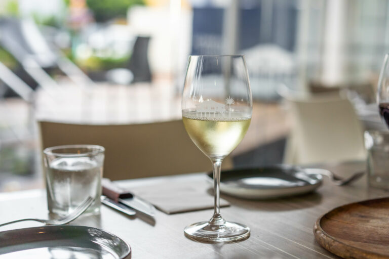 table set with a glass of white wine ready for guest