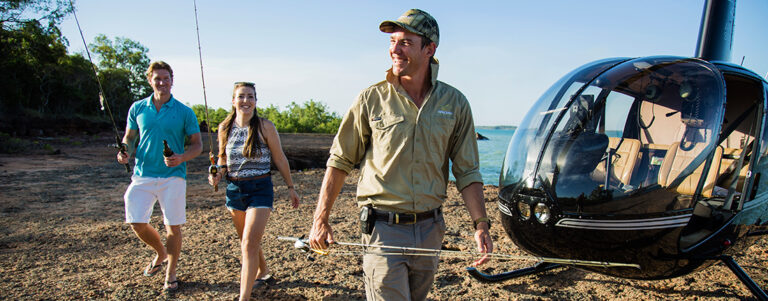 three people walking away from helicopter
