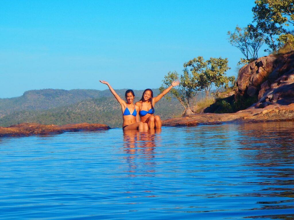 two girls sitting at natural pool in Northern Territory