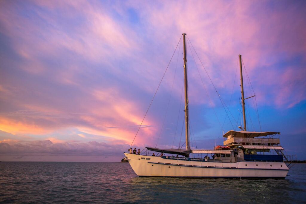 sunset in the backdrop of a boat in the water