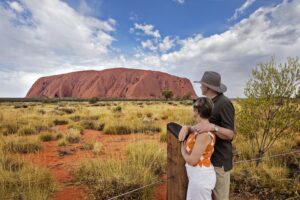 two tourists viewing Uluru at sunset