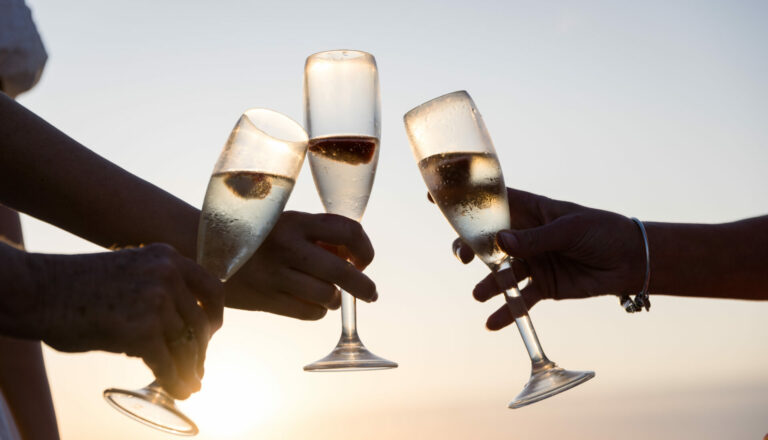 Glasses clinking at sunset